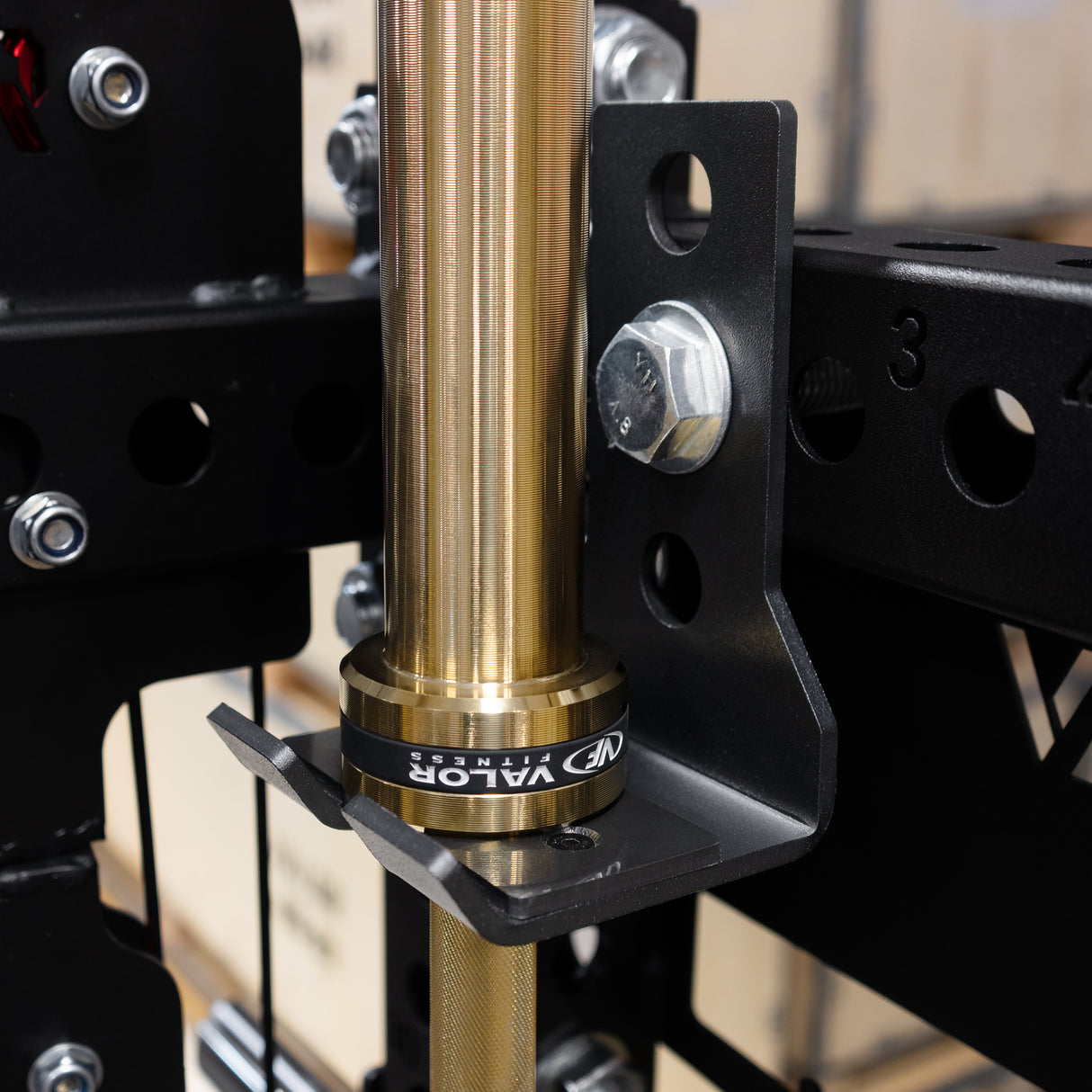 Close-up of a gold metal barbell with a black bracket on a functional gym trainer