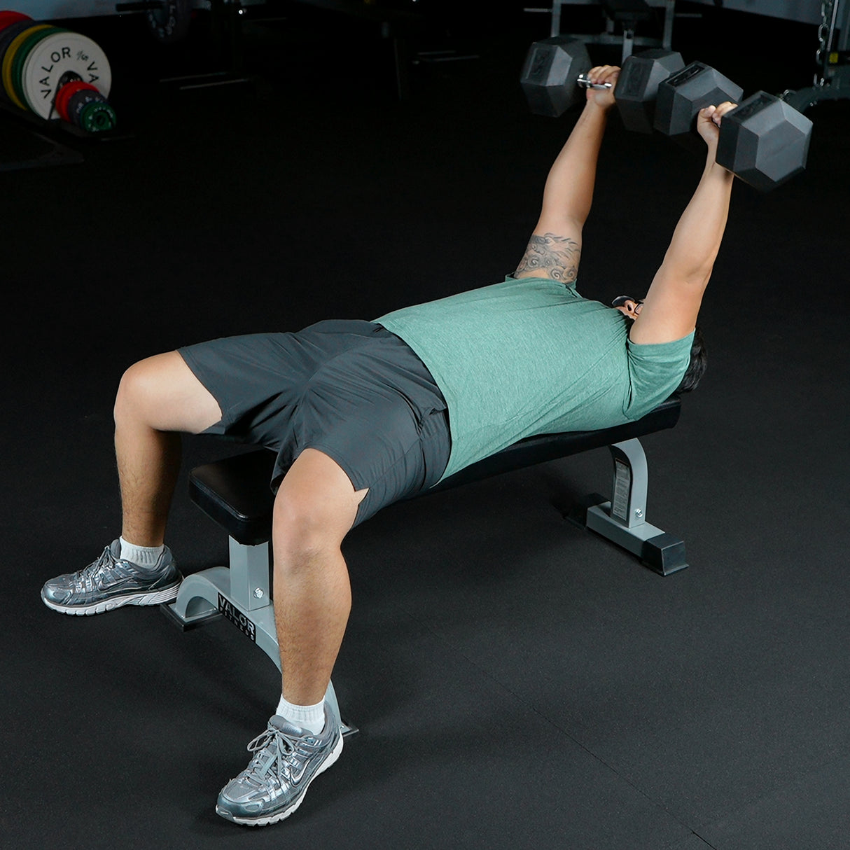 Overhead dumbbell presses using a stationary flat bench