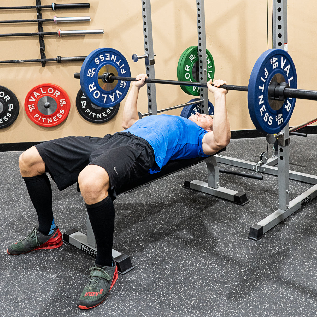 Flat bench press with black barbell and pro fitness rack
