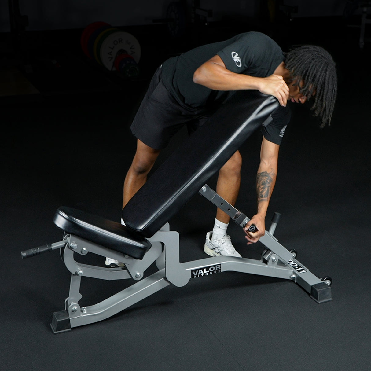 Person adjusting a flat incline weight bench