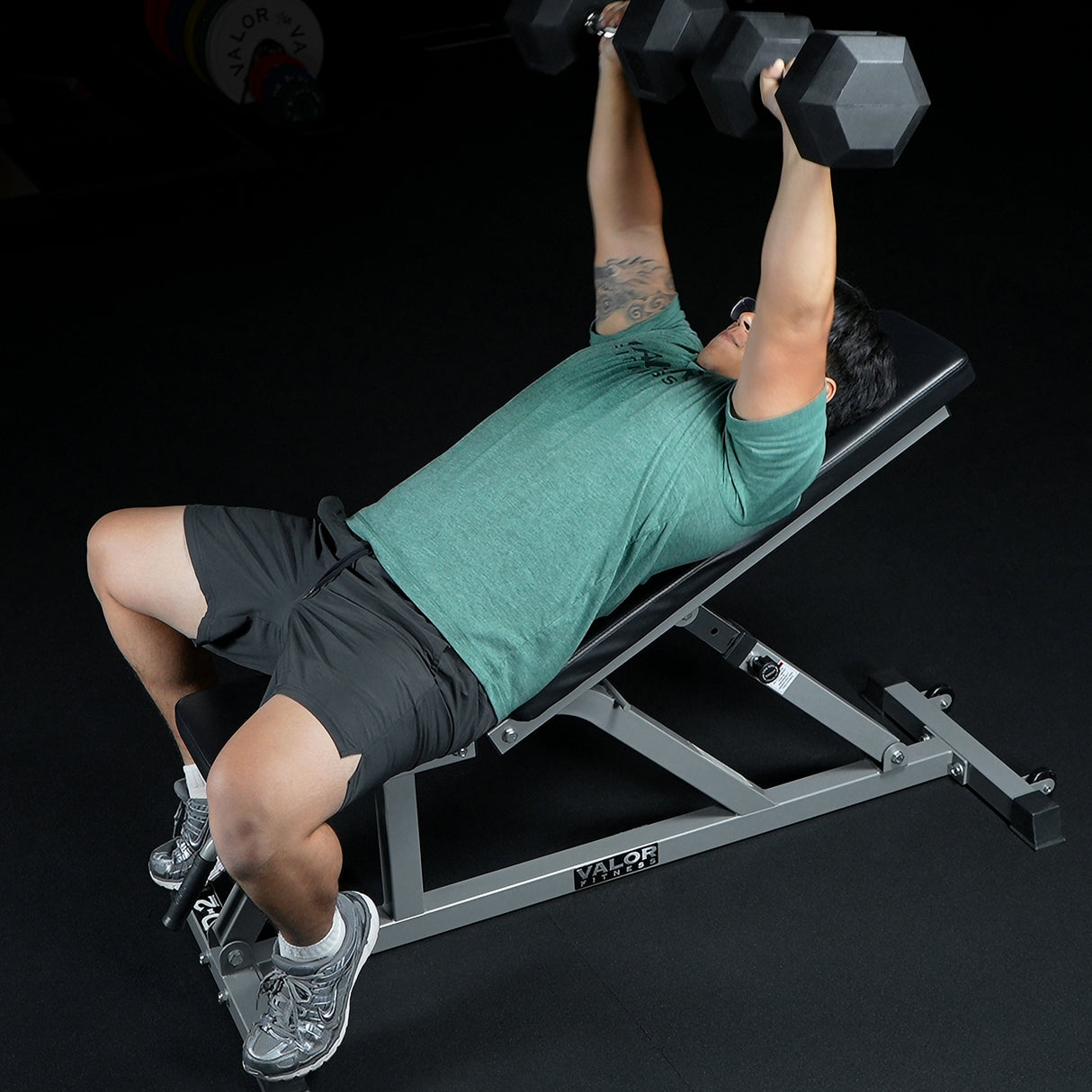 Person performing bench press with dumbbells on an adjustable weight bench