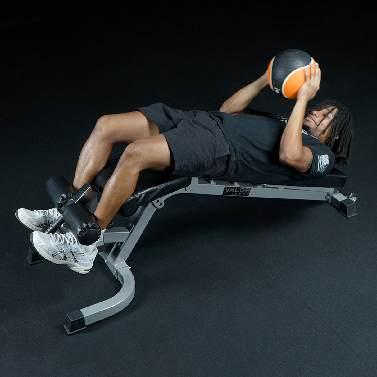 Person using a weight bench with a medicine ball