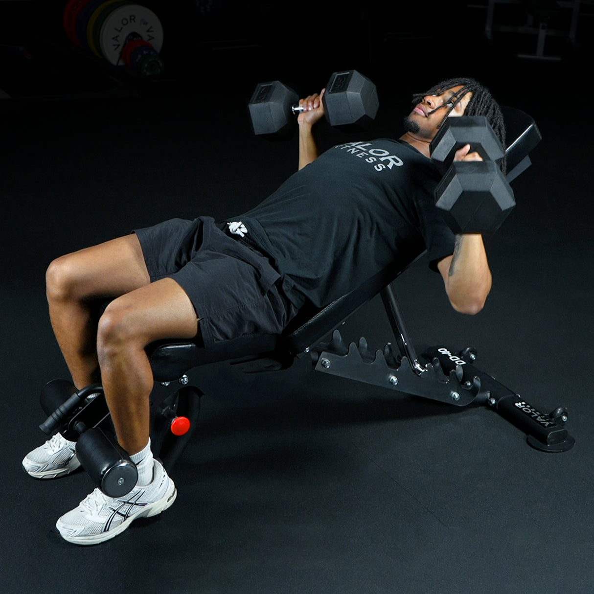 Person performing bench press with dumbbells on a fid weight bench