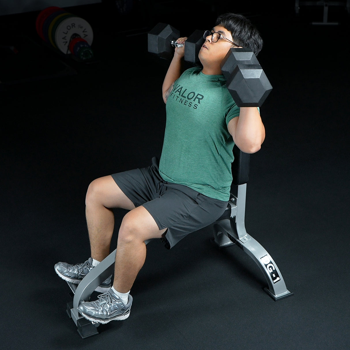 Overhead presses with dumbbells on a seated upright weight bench
