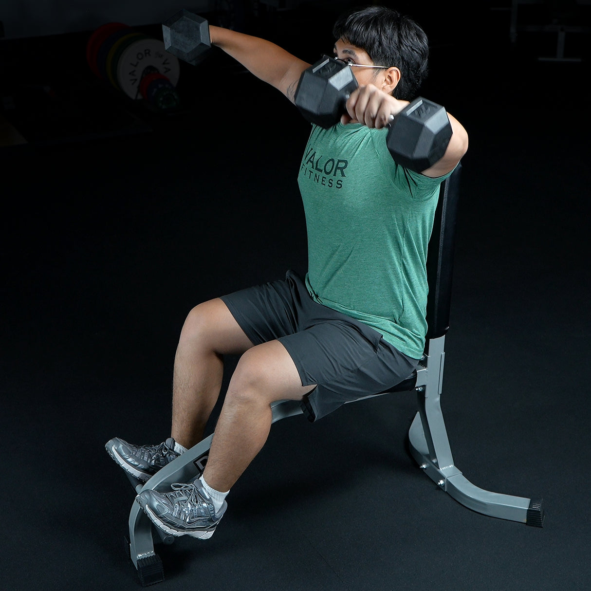 Lat raises with dumbbells on a seated upright weight bench