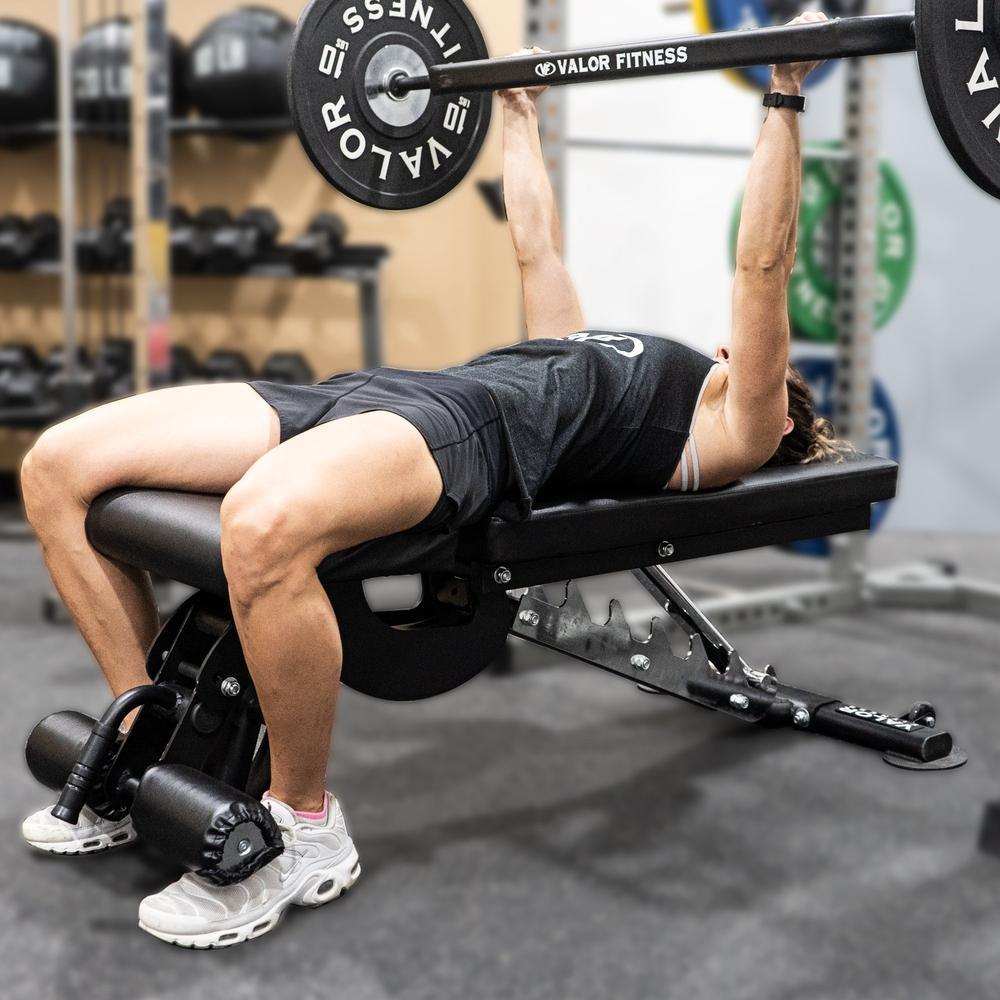 Exercising bench presses on a flat-incline-decline weight bench using a multi-grip barbell
