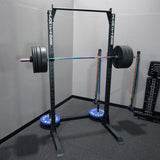 Squat rack with barbell and weight plates in a gym setting