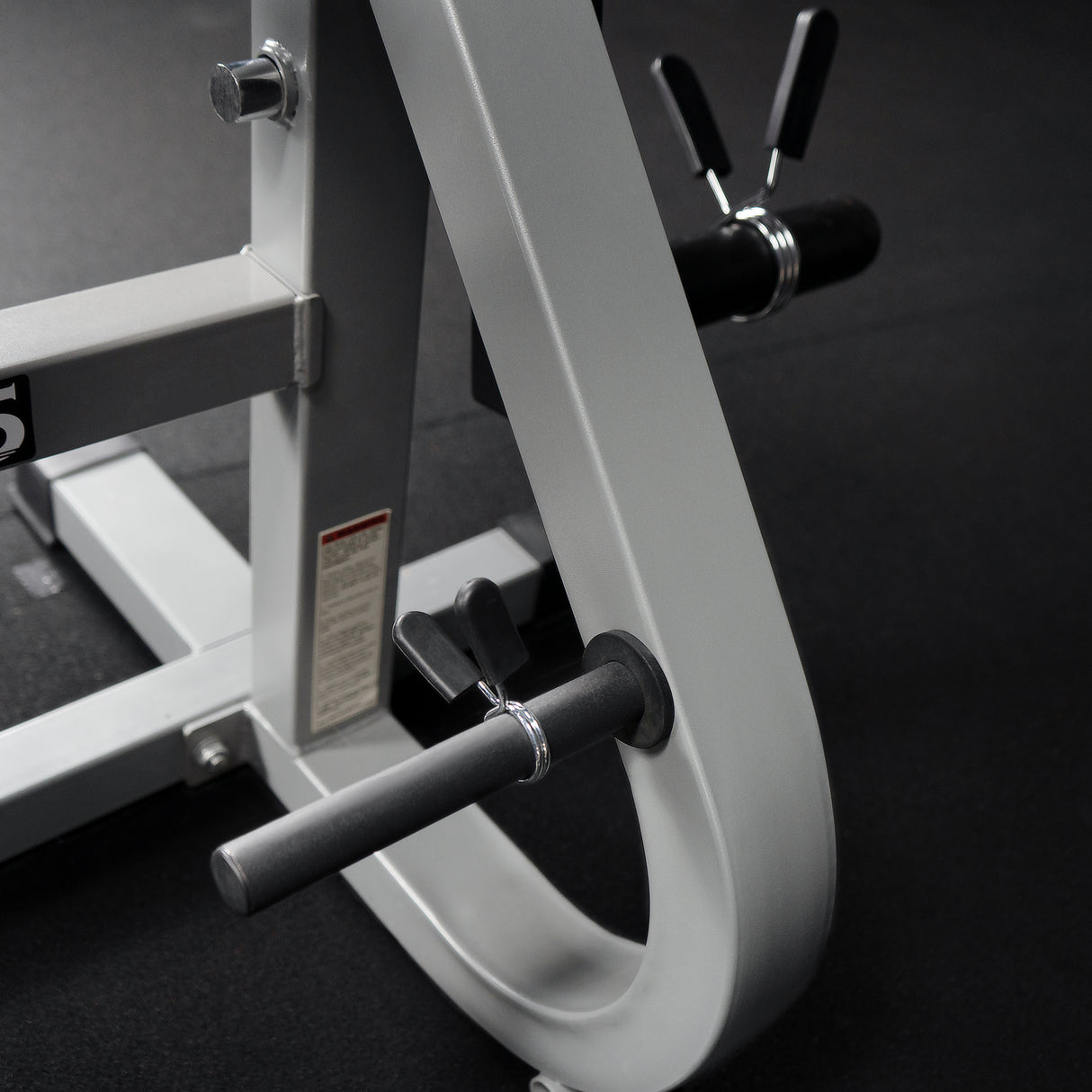 Included plate storage adapters and spring clips on a workout machine